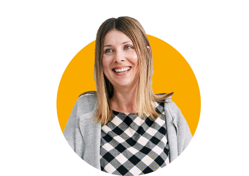 Eine Lehrkraft lächelt vor einem einfarbigen gelben Hintergrund.