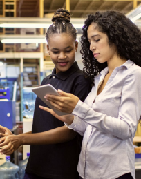 two women looking at a tablet