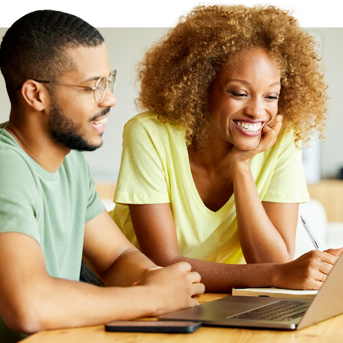 Two people working together, looking at a laptop screen
